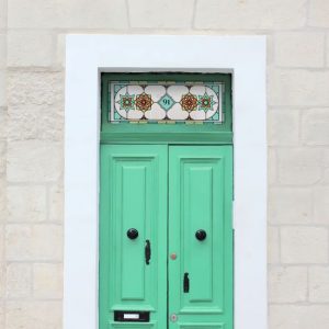 Sean Stained glass window film with flowers and a central number installed above an old green door
