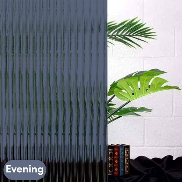 A blue grey reeded window film in front of a house plant.