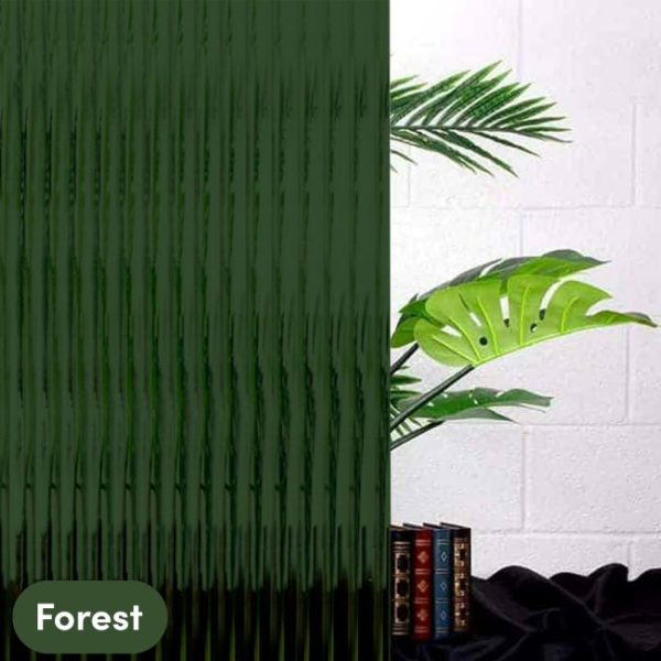 A forest dark green reeded window film in front of a plant and books