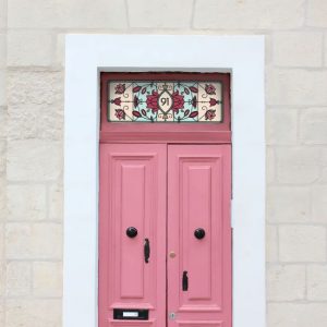 lee stained glass window film with door number and red flowers and lotus installed onto a pink door.