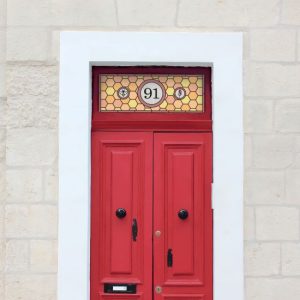 Honey comb stained glass window film in orange and yellow with a central door number
