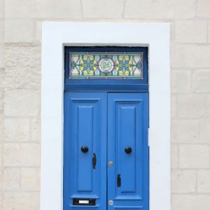 Harry flower stained glass window film with a central door number installed above a blue front door