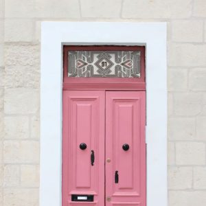 line design stained glass window film with central door number installed above a pink door