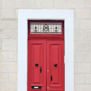 floral stained glass window film installed on a red door