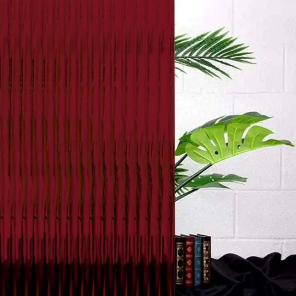 red reeded glass with a green plant behind.