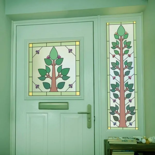 two stained glass window films in a tree design with a green border and various berries