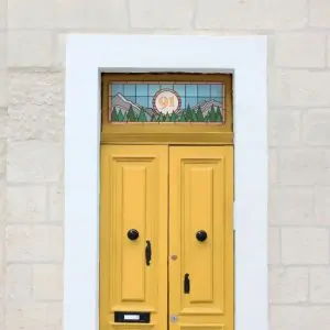 A modern stained glass door number with a blue background, mountains and trees